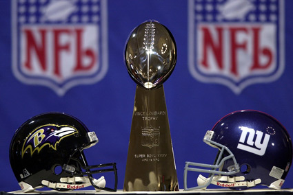 The Ravens and Giants helmets post with the Lombardi Trophy. (Baltimore Sun)